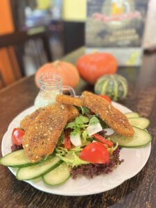 Crispy fried pumpkin on a crisp salad and pumpkin seed decoration